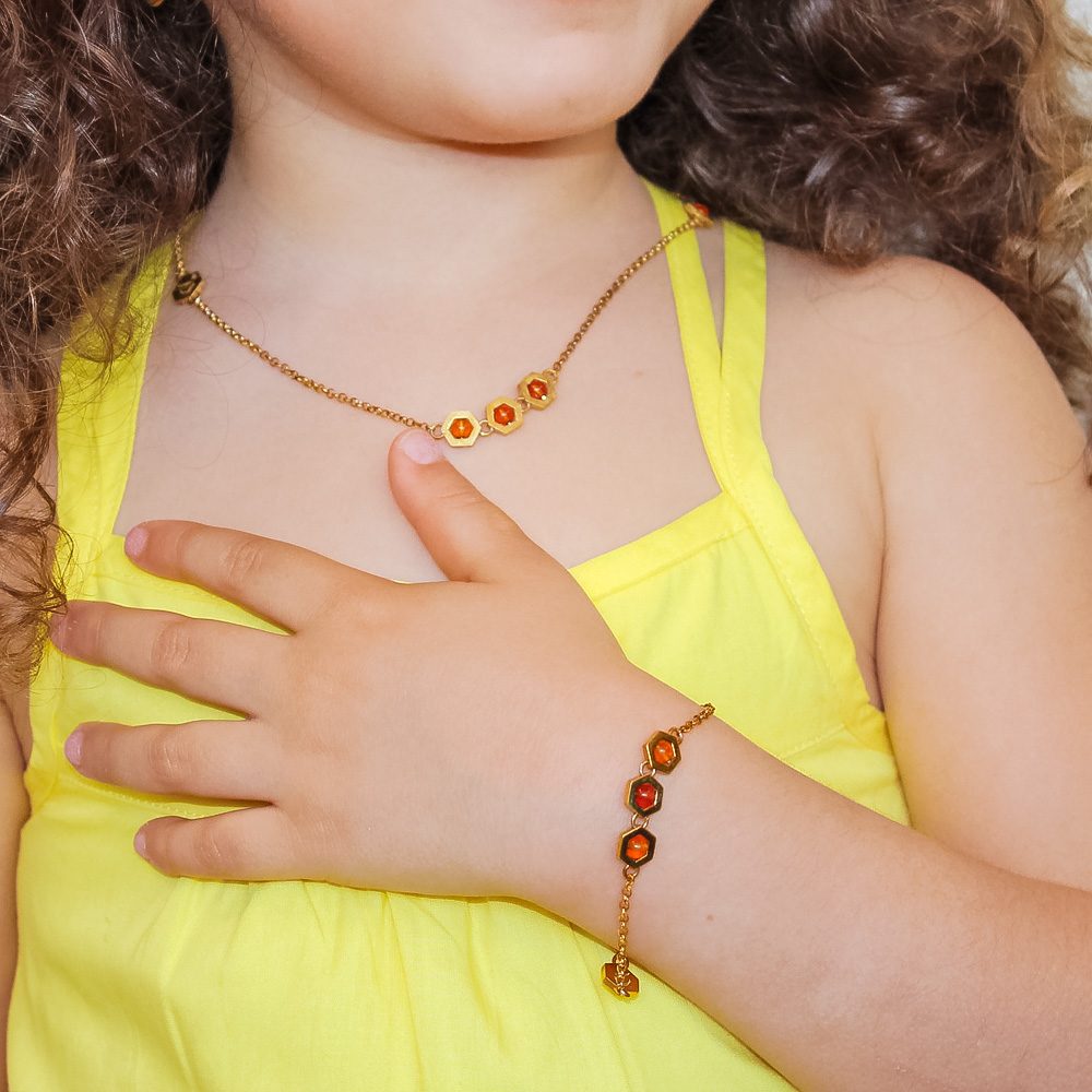 bambina con bracciale e collana in argento dorato e ambra